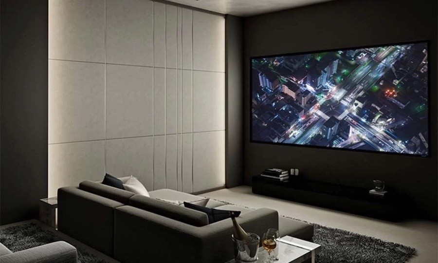 Luxury home theater space with plush couch and large Stewart film screen display.