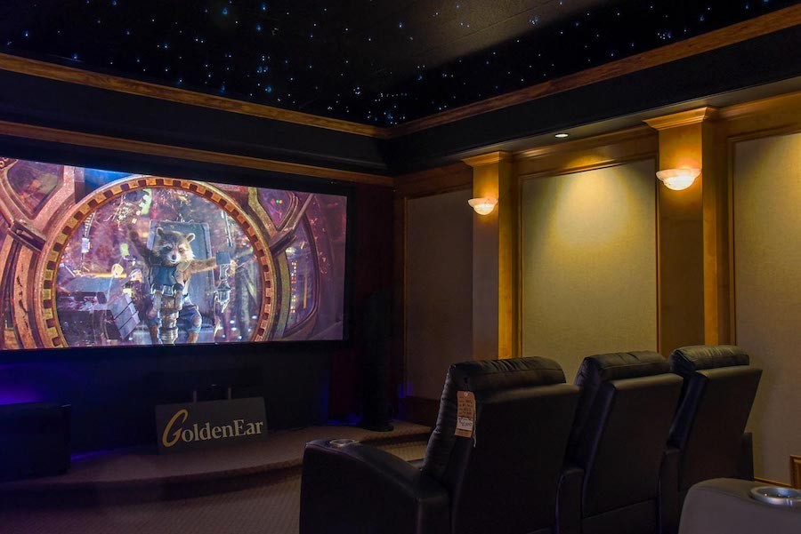  large home theater space with a superhero movie on the screen and leather seats in the foreground